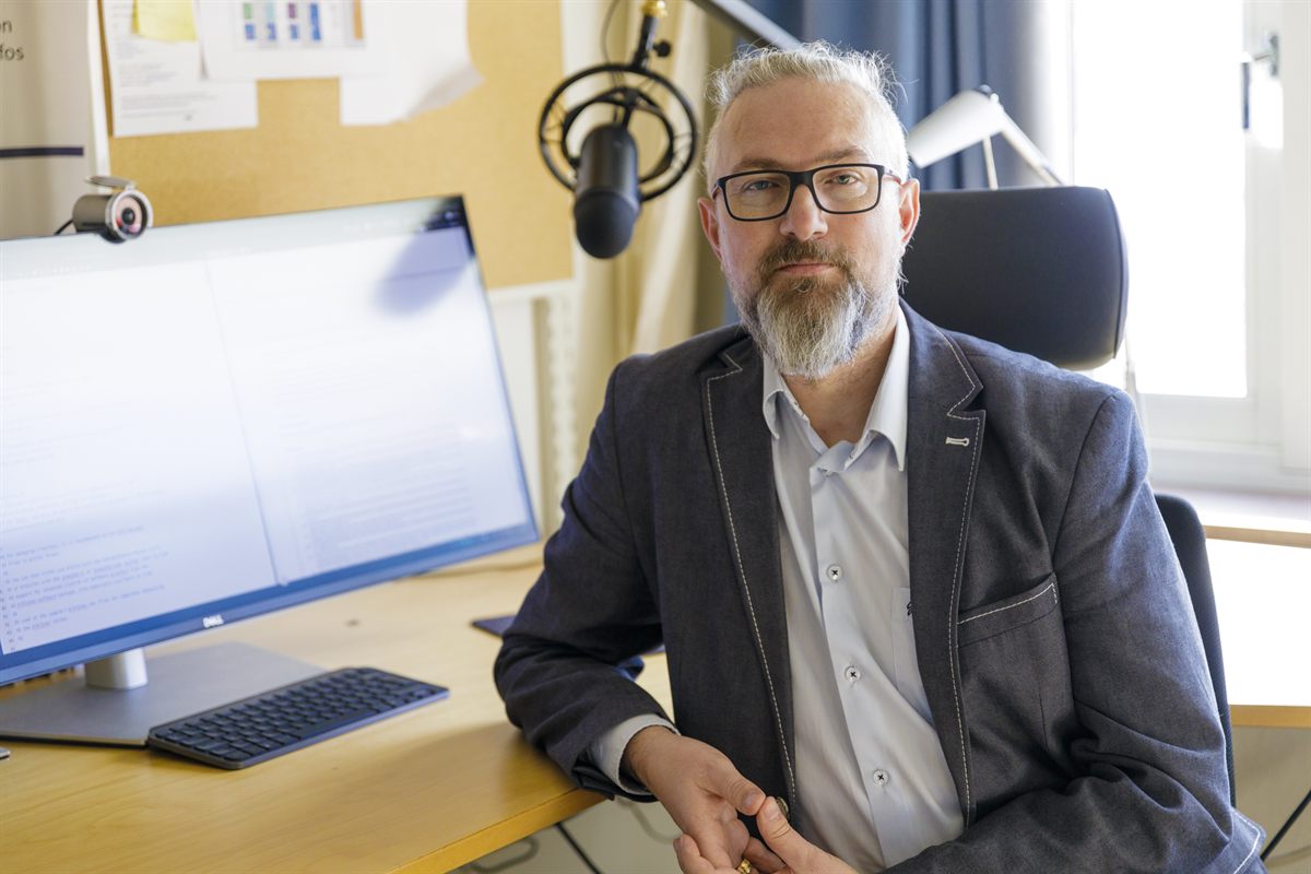 Miroslaw's personal image. Sitting at the desk in his office.